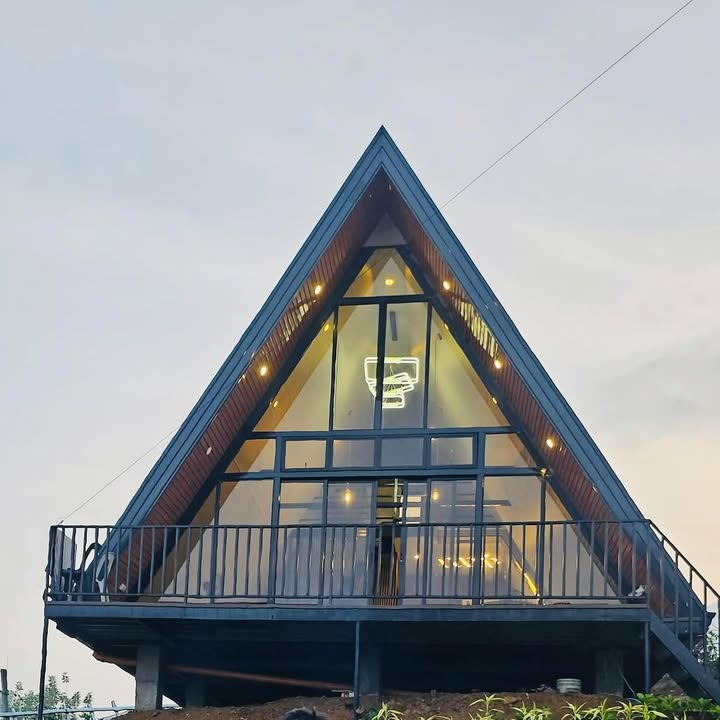 The Heights Catigan's tall glass facade at blue hour, warm light glowing inside